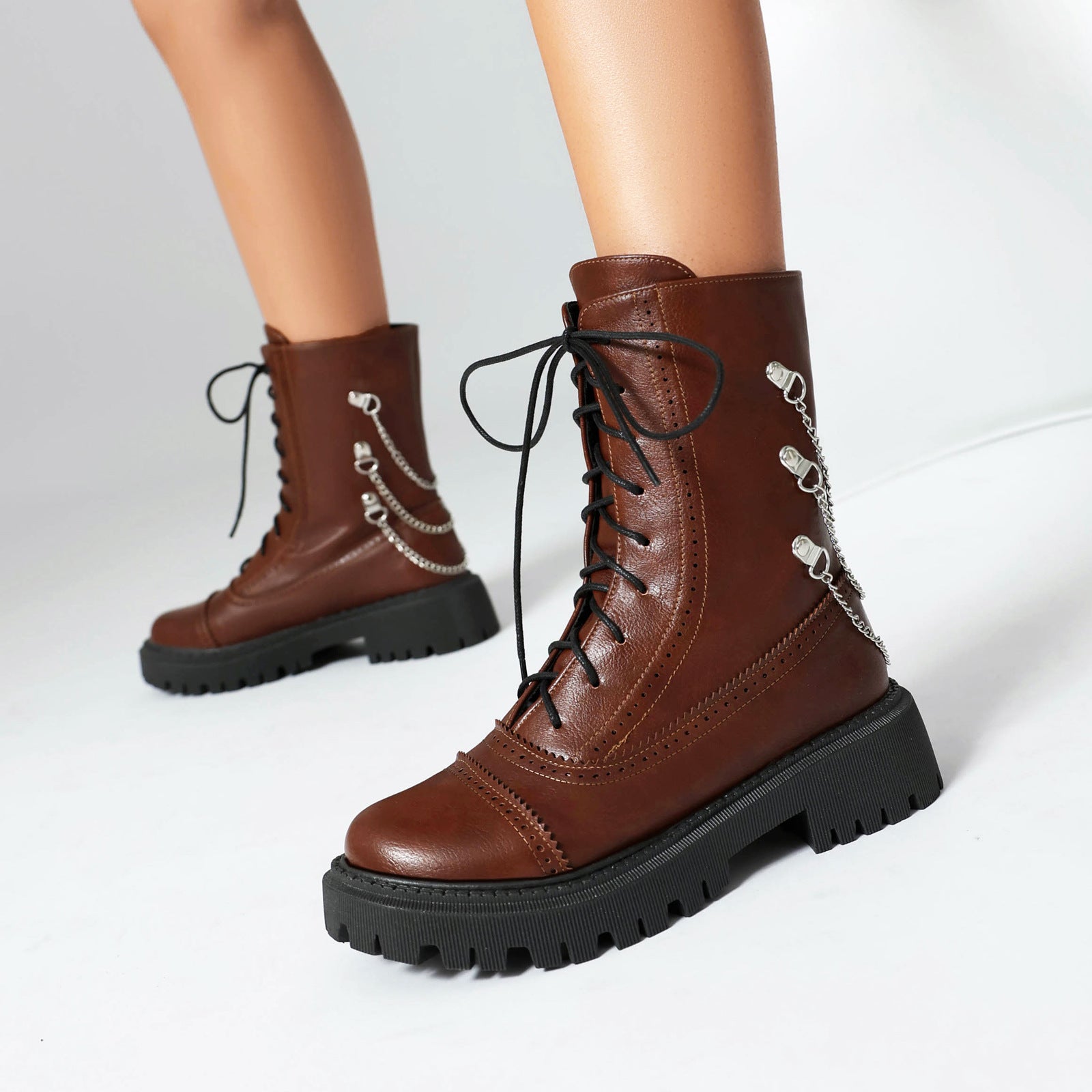 Brown leather boots with black laces on a white background
