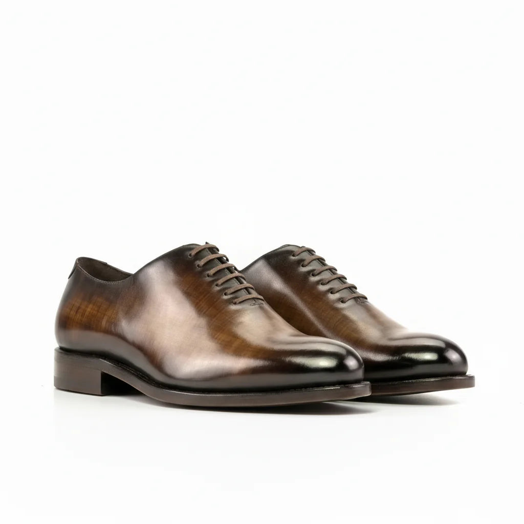 Pair of brown leather dress shoes on a white background