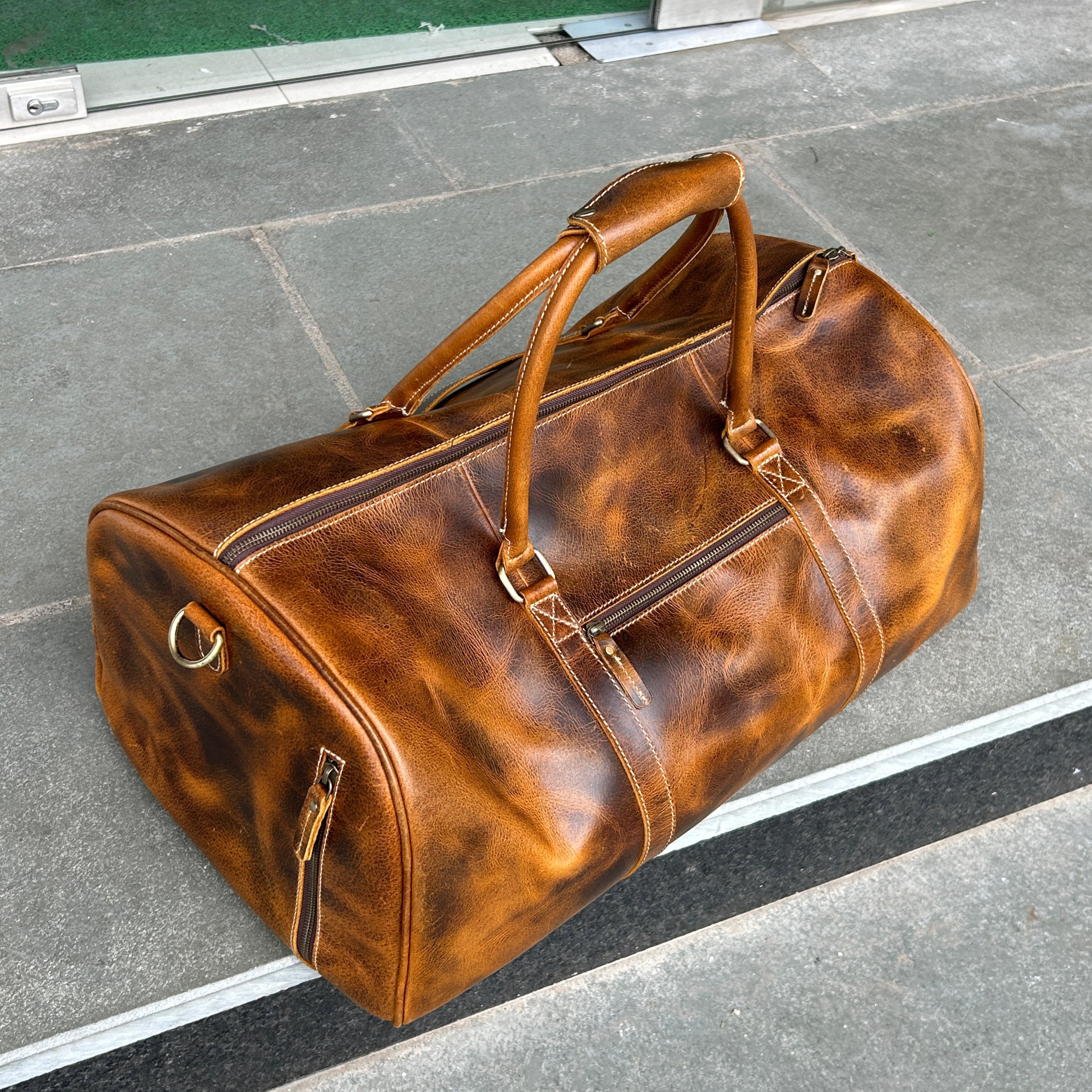 Brown leather duffel bag on a gray pavement