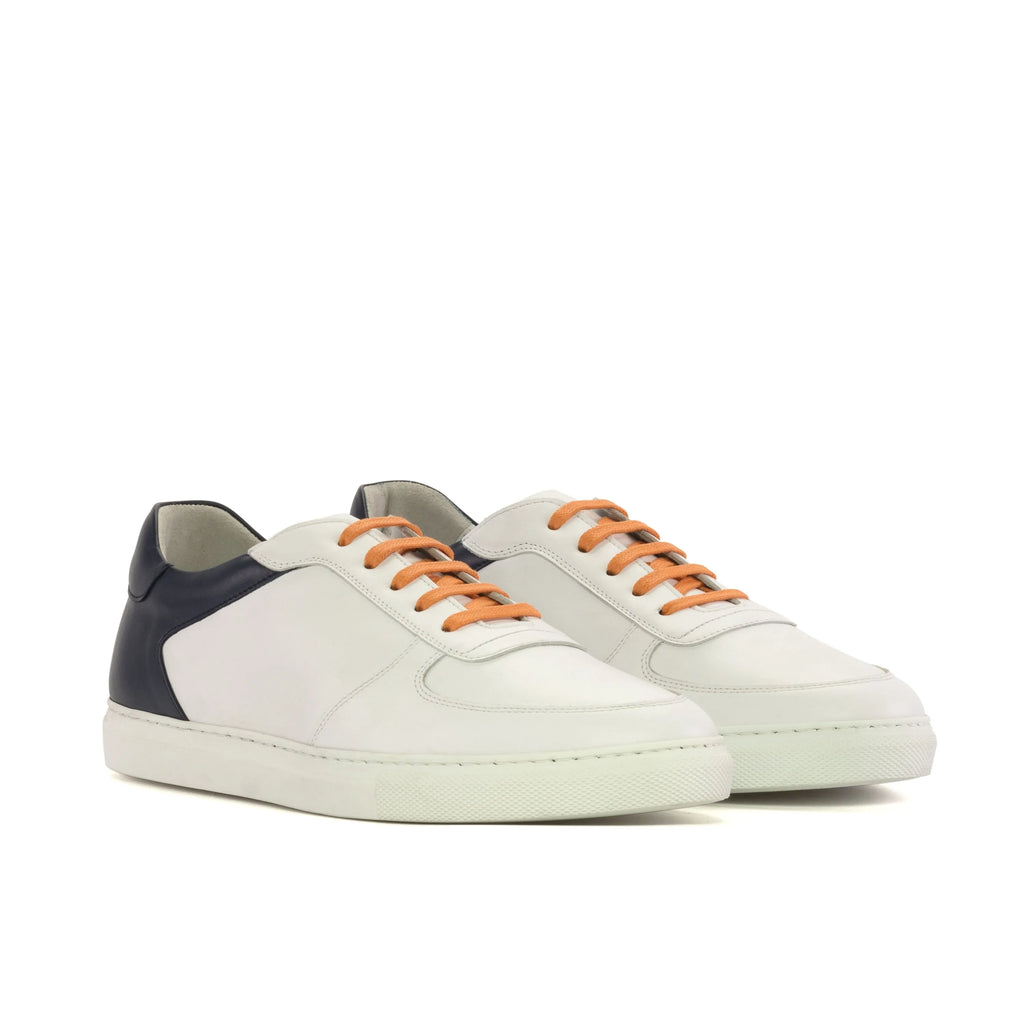 White sneakers with orange laces on a white background